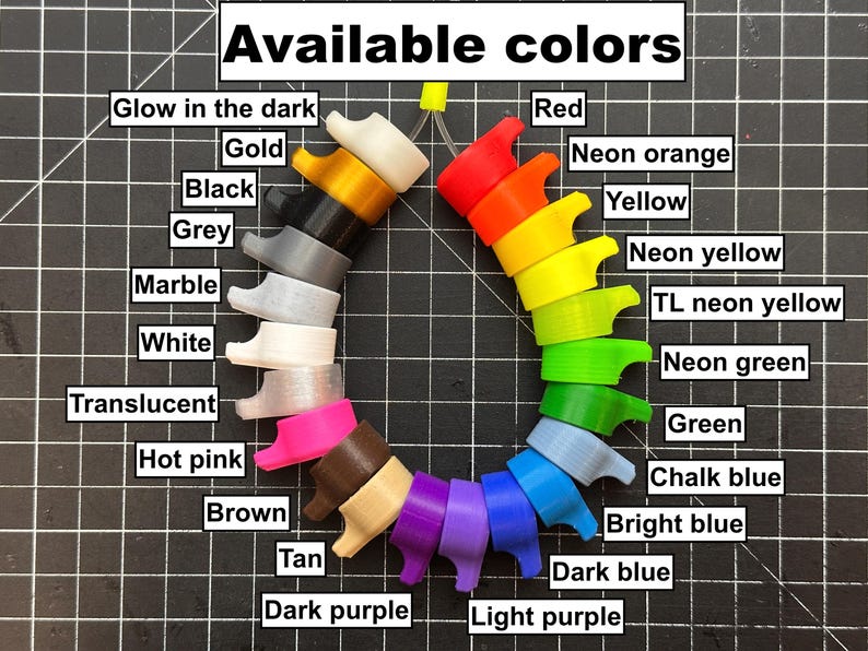 May include: A variety of colorful, 3D-printed objects are arranged in a circular pattern. The image displays a range of colors, including red, yellow, green, blue, and purple, as well as neutral tones like black, white, and grey. Text at the top reads "Available colors."