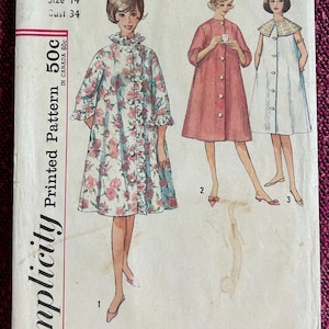 May include: Vintage Simplicity sewing pattern 4708 for Misses' robes. The pattern features three robe designs, including a floral print robe with ruffles, a solid pink robe, and a white robe with a decorative collar. Size 14, bust 34 inches.