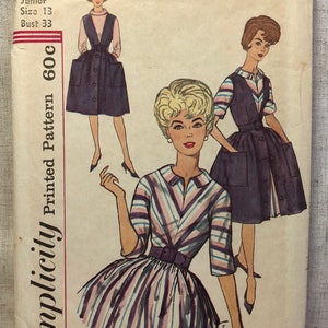 May include: Simplicity Printed Pattern 600c, a vintage sewing pattern for a junior size 13 dress with a bust measurement of 33 inches. The pattern features two different styles: a striped dress with a belt and a sleeveless dress with pockets.