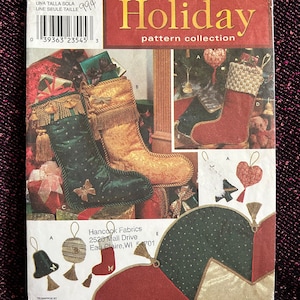 Può includere: Modello di cucito Simplicity Holiday per realizzare calze di Natale, ornamenti e altre decorazioni natalizie. Il modello include istruzioni per realizzare una varietà di modelli, tra cui una calza con bordatura dorata, un ornamento a forma di cuore e un ornamento a forma di campana.