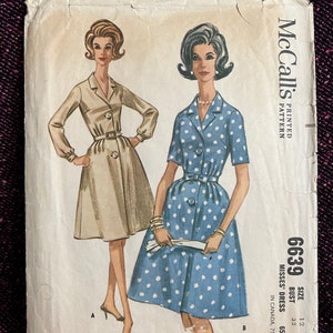 Puede incluir: Patrón de costura vintage de McCall's para un vestido de mujer. El patrón es para la talla 12, busto 81 cm. El patrón muestra dos modelos con el vestido, uno en color beige y el otro en azul y blanco con lunares.