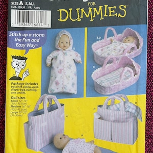 May include: Simplicity sewing pattern for baby dolls, including a bassinet, diaper bag, and bunting. Doll sizes range from 30.5cm to 56cm. The pattern includes instructions for making a bassinet, pillow, quilt, diaper bag, bunting, and undies.