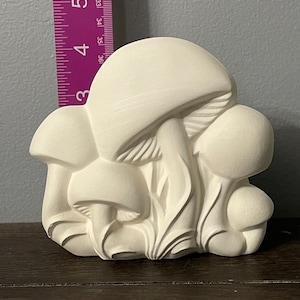 May include: White ceramic mushroom sculpture with three mushrooms clustered together. The mushrooms have detailed textures and are arranged in a natural pose.