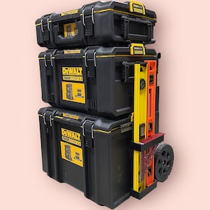 May include: A stack of three black toolboxes with yellow accents. The top toolbox has the text "DEWALT TOUGH SYSTEM 2.0" printed on the front. The bottom toolbox has a yellow and red level attached to the side.