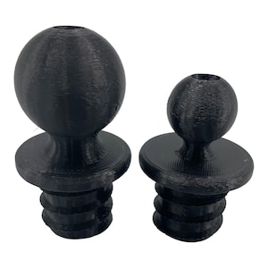 Peut inclure: Deux pieds de meubles en plastique noir en forme de boule avec des bases filetées. Le plus grand pied mesure environ 5 cm de diamètre et le plus petit pied mesure environ 2,5 cm de diamètre.