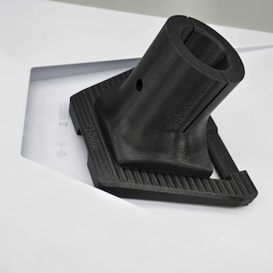May include: A black plastic 3D printed adapter with a 45mm diameter opening. The adapter has a square base with a textured surface.