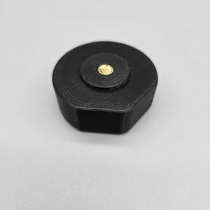May include: A black plastic hexagonal camera mount with a threaded hole in the center.