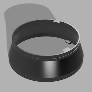 May include: A matte black, circular, tapered ring component featuring a smooth exterior surface and a hollow interior. The inner rim includes three small, evenly spaced rectangular tabs protruding inward, designed for mechanical alignment or locking.