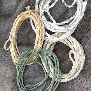 Könnte beinhalten: Vier verschiedene Arten von geflochtenem Seil, darunter ein weißes Seil, ein braunes Seil, ein braunes Seil und ein grün-braunes Seil.