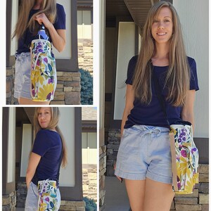 May include: A floral water bottle carrier with a shoulder strap. The carrier features a yellow, purple, and blue floral pattern on a white background. It has a drawstring closure and a side pocket. The strap is black and tan.
