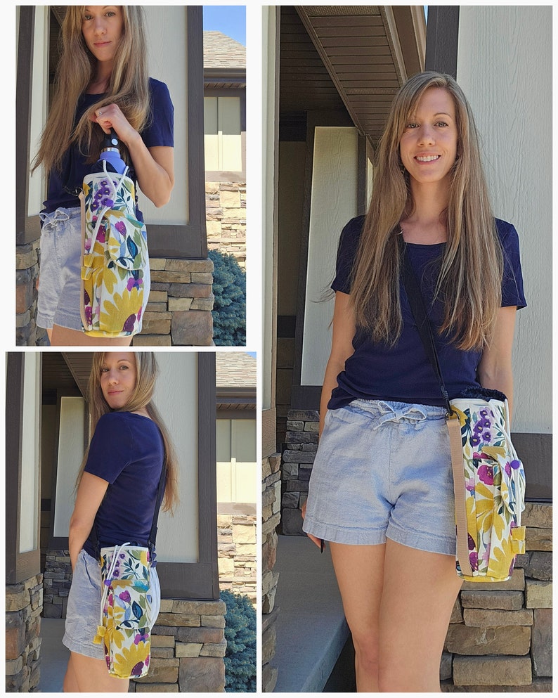 May include: A floral water bottle carrier with a shoulder strap. The carrier features a yellow, purple, and blue floral pattern on a white background. It has a drawstring closure and a side pocket. The strap is black and tan.