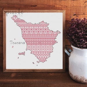 May include: A cross-stitch pattern of the region of Tuscany, Italy, in red and white thread. The pattern is framed and the word "Toscana" is stitched in the bottom left corner.
