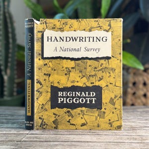 May include: A hardcover book titled Handwriting: A National Survey by Reginald Piggott. The yellow cover features a collage of envelopes and letters. The black spine displays the title and author name in white text against a yellow background.
