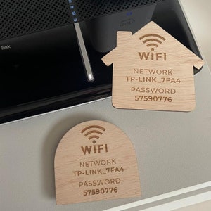 Pu&ograve; includere: Due cartelli in legno, uno a forma di casa e l'altro a forma di arco, entrambi con un simbolo wifi e il testo "WIFI", "NETWORK", "TP-LINK_7FA4", "PASSWORD" e "57590776".