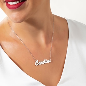 May include: A silver necklace with the name "Caroline" spelled out in cursive script.