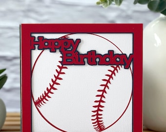May include: Red and white baseball card with a baseball in the center and the words "Happy Birthday" in red letters on top of the baseball. The card is surrounded by a red border.