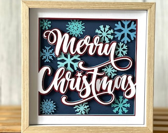 May include: A digital download of a framed image with the text "Merry Christmas" in white with a red outline. The background is blue with white snowflakes.