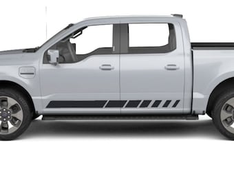 May include: A silver pickup truck with black side stripes. The truck has a black bed and a black antenna.
