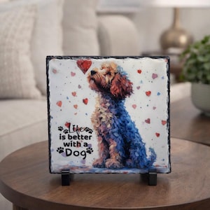 May include: A square decorative slate tile featuring a watercolor illustration of a dog with red and blue fur, surrounded by heart shapes. The text "Life is better with a Dog" is printed on the bottom.