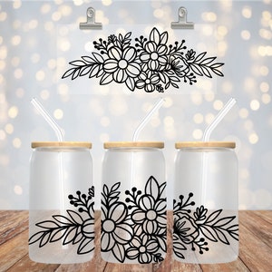 May include: Three clear glass tumblers with black floral designs and wooden lids. Each tumbler has a clear glass straw.