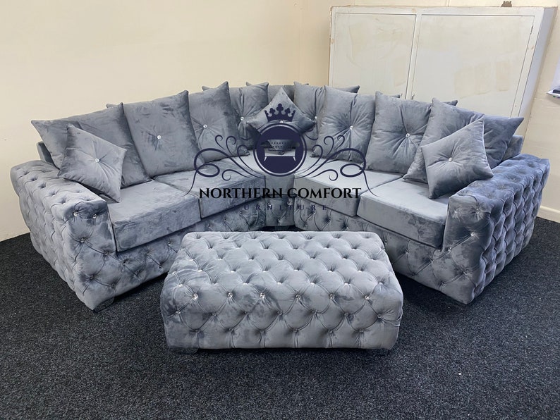 May include: A gray sectional sofa and matching ottoman set. The sofa features a tufted design with crystal-like buttons and plush cushions. The ottoman is rectangular and also tufted. The logo "NORTHERN COMFORT" is visible.