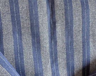 May include: Blue and white striped fabric with a subtle diagonal pattern. The fabric is folded in half, showing the pattern on both sides.