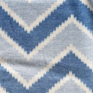 May include: Blue and white fabric with a chevron pattern. The fabric has a textured surface.