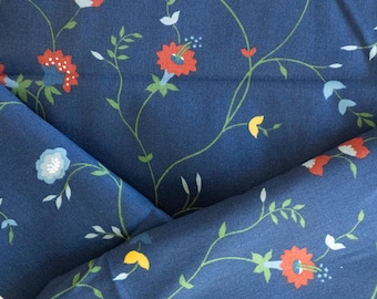 Könnte beinhalten: Nahaufnahme eines marineblauen Stoffes mit floralem Muster. Das Design zeigt rote, weiße und gelbe Blumen mit grünen Stielen und Blättern. Der Stoff ist gefaltet und zeigt die Wiederholung des Musters.