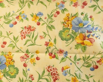May include: A floral fabric with a light yellow background. The pattern features a variety of flowers in shades of blue, yellow, red, and pink, along with green leaves and red cherries. The design is spread across the fabric.