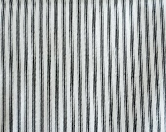 May include: Close-up of a fabric with a classic ticking stripe pattern. The fabric features vertical stripes in a dark gray color against a white background. The stripes are evenly spaced, creating a simple, yet elegant design. This textile is suitable for various home decor projects.