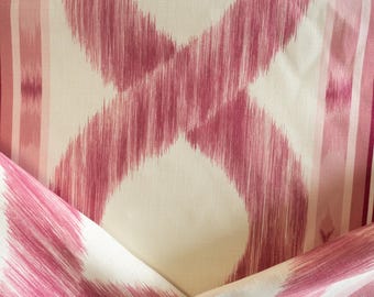 Puede incluir: Primer plano de tela con fondo crema y un patrón de pinceladas magenta que se cruzan. Rayas verticales en tonos rosa y blanco en el lado derecho. La tela está doblada, mostrando el patrón desde diferentes ángulos.