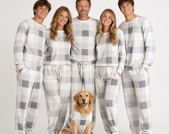 Peut inclure: Un ensemble de hauts à manches longues et de pantalons de jogging assortis avec un grand motif à carreaux gris et blancs. Les vêtements ont une encolure ronde et une taille élastique avec un cordon. Un chien porte une chemise assortie.