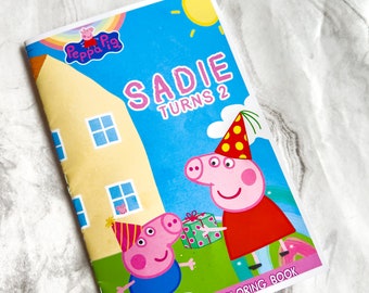 Peut inclure: Un mini livre d'activités et de coloriage Peppa Pig avec un cochon rose portant un chapeau de fête et tenant un cadeau. Le livre a un fond bleu, jaune et blanc avec le texte "Sadie Turns 2".