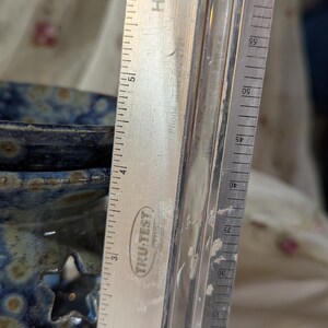 K&ouml;nnte beinhalten: Ein Metalllineal mit dem Text "TRU-TEST" und "HARDE" befindet sich neben einer blauen Keramikschale mit sternf&ouml;rmigen Aussparungen. Das Lineal zeigt Messungen in Zentimetern, bis zu 15 cm.
