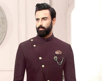 May include: A maroon three-piece suit with a mandarin collar, gold buttons, and a pocket square. The suit has a long, asymmetrical jacket with a single button closure.