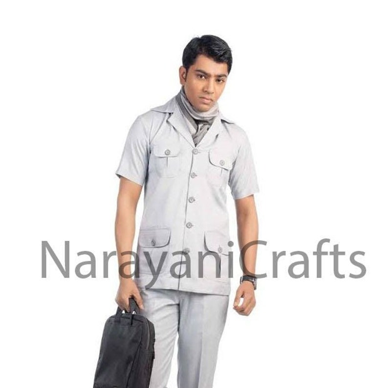 May include: A white short-sleeved collared shirt with a button-up front and multiple pockets. The shirt is paired with matching white pants. The model is wearing a gray scarf around his neck. The text "NarayaniCrafts" is visible in the bottom center of the image.