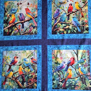 Peut inclure: Quatre panneaux de tissu avec des illustrations d'oiseaux vibrants. Chaque panneau présente des oiseaux colorés perchés sur des branches d'arbres, sur fond de feuillage. Les panneaux sont encadrés d'une bordure bleue, créant un design cohérent.