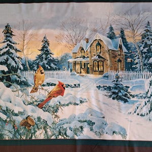 May include: A winter scene textile depicting a snow-covered landscape with a house and two cardinals. The house has lit windows, a white picket fence, and a snowy path. The cardinals are perched on snow-covered branches. The colour palette includes shades of white, brown, and red.