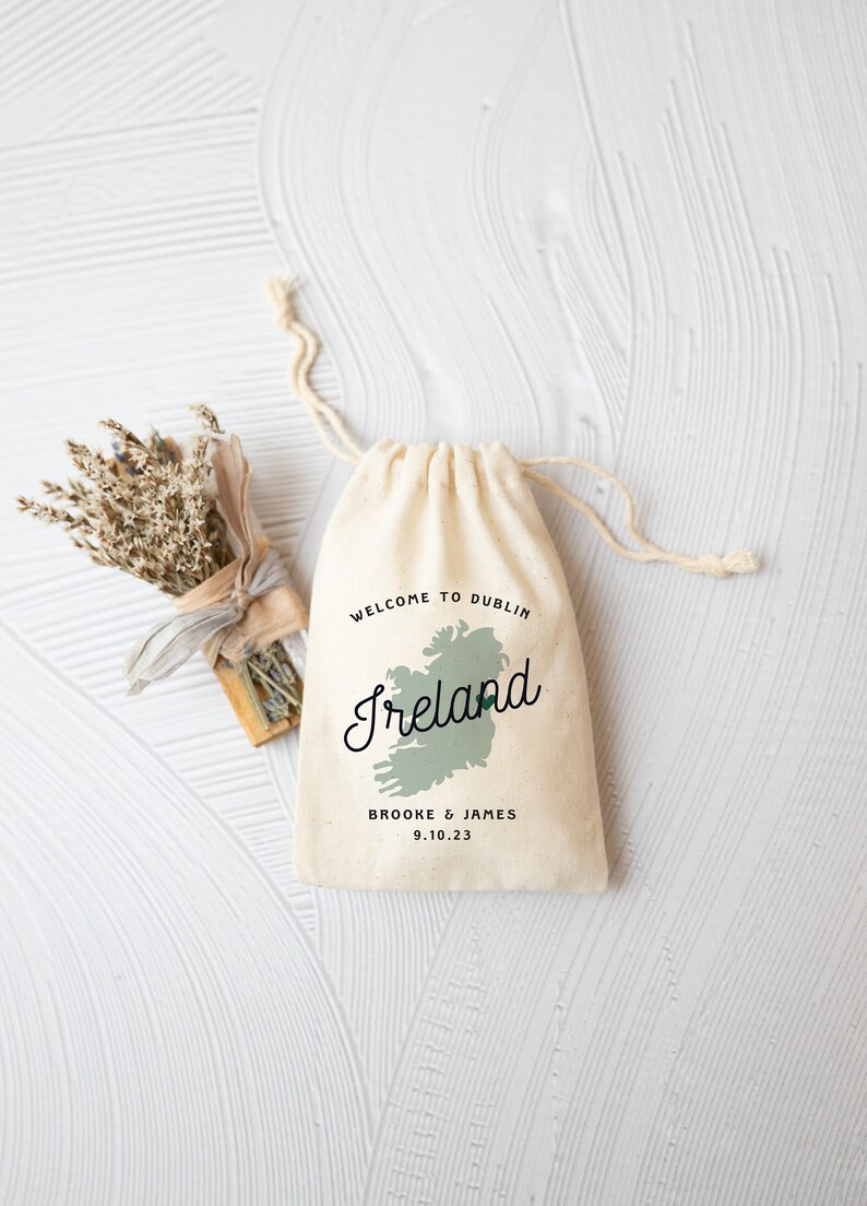 May include: A white drawstring bag with the text "Welcome to Dublin, Ireland" and a green outline of the country of Ireland. The bag also has the text "Brooke & James 9.10.23".