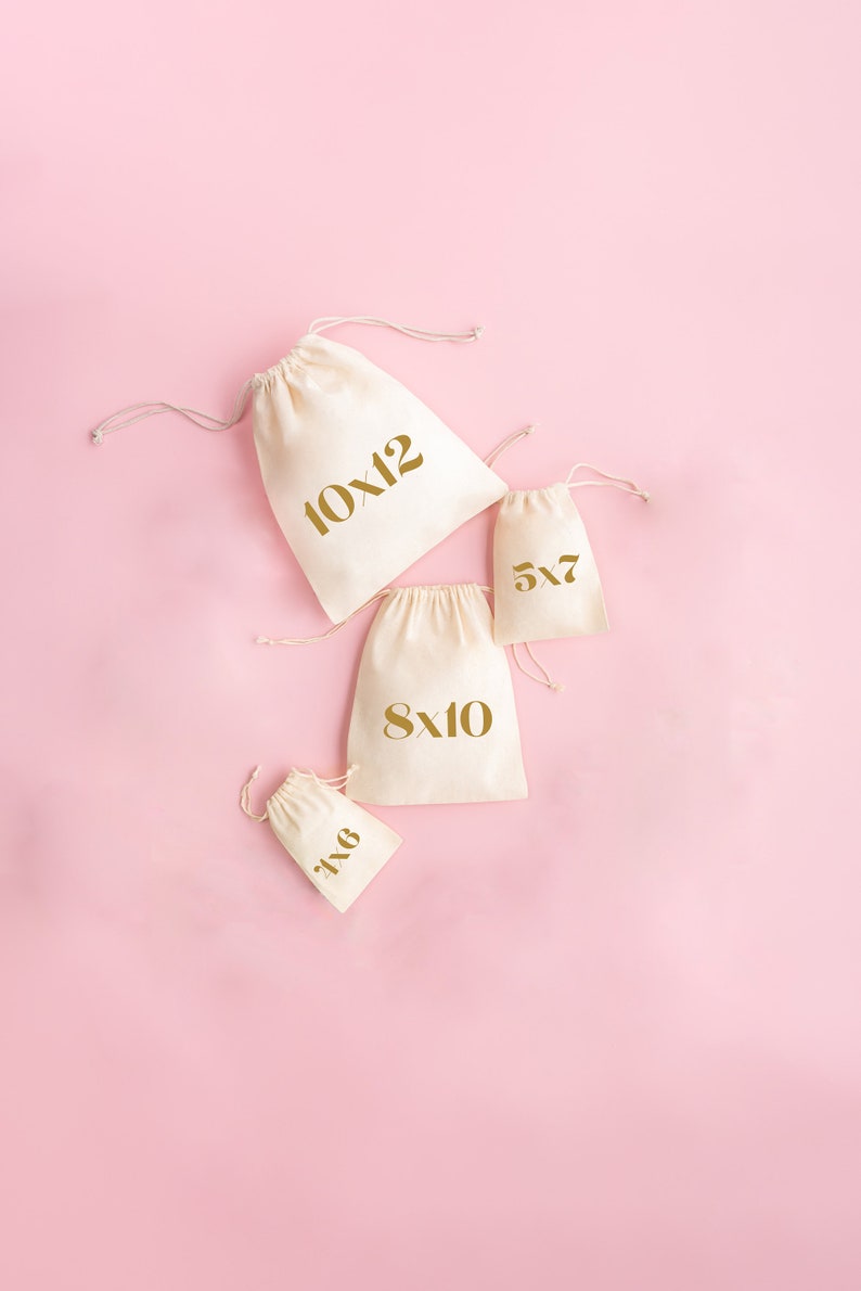 May include: Four white cotton drawstring bags with gold lettering on a pink background. The bags are labeled with different sizes: 10x12, 8x10, 5x7, and 6x8.