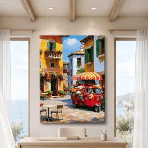 Peut inclure: Une impression d'art mural rectangulaire représentant une scène de rue méditerranéenne vibrante avec des bâtiments jaunes et blancs, un véhicule rouge à trois roues transportant des fleurs colorées sous un parasol rayé orange et blanc.