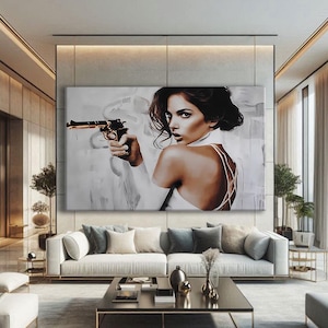 Peut inclure: Grande impression d'art sur toile représentant une femme tenant une arme à feu dorée, vêtue d'une robe blanche sur fond neutre. L'œuvre est signée Alassio Cacciatore, Galerie D'Art. La femme regarde par-dessus son épaule.