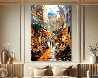 May include: A large, framed canvas print depicting a vibrant street scene with a blue-domed building in the background. The artwork features people dining at tables, with warm orange and yellow tones dominating the scene. The print is displayed above a bed.