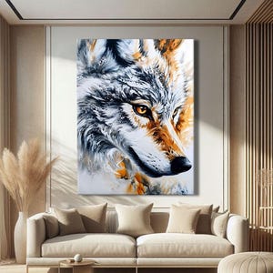 Könnte beinhalten: Ein großer Leinwandkunstdruck mit einem detaillierten Porträt eines Wolfskopfes. Das Kunstwerk zeigt den Wolf in einer Mischung aus Weiß-, Grau- und Orangetönen, wobei der Fokus auf den Augen liegt. Das Gemälde wird in einem modernen Wohnzimmer präsentiert.