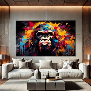 Op de afbeelding: Een levendig, groot canvas kunstwerk met een gorillaportret met een kleurrijk, abstract verfspatterontwerp. Het gezicht van de gorilla is gedetailleerd, met een serieuze uitdrukking. Het kunstwerk gebruikt een palet van blauw, rood, geel en oranje.