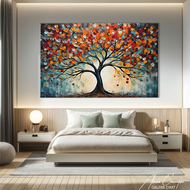 May include: Large abstract tree painting with a dark trunk and branches, and colorful leaves in shades of red, orange, and blue. The artwork hangs above a bed in a modern bedroom setting. The painting is signed by the artist.