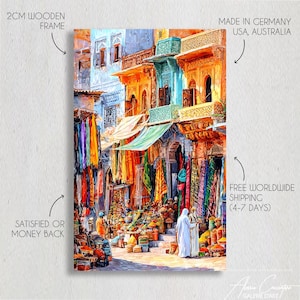 May include: A colourful painting of a marketplace with textiles and buildings. The artwork has a 2cm wooden frame and the text "SATISFIED OR MONEY BACK". The painting is made in Germany, USA, and Australia.