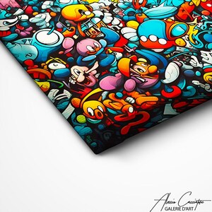 May include: A canvas print featuring a dense, colorful graffiti-style collage of cartoon characters in shades of blue, yellow, red, and pink against a black background. The bottom right corner displays the text Alasio Cacciatore GALERIE D'ART.