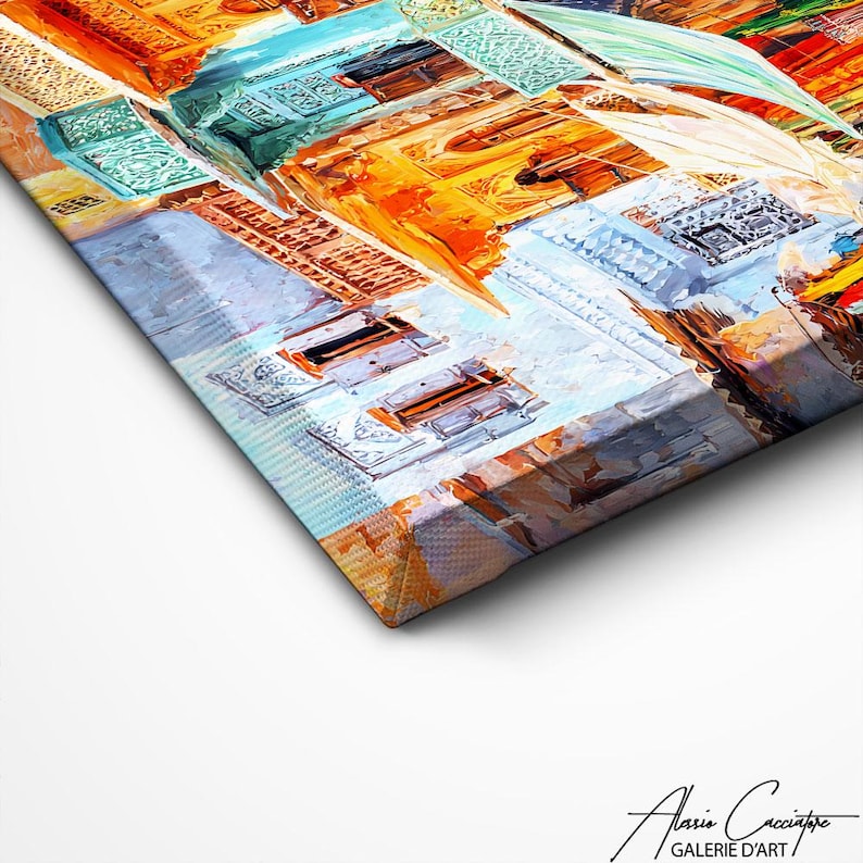 May include: An abstract canvas painting depicting a cityscape with a perspective view. The artwork uses a palette of warm and cool colours, such as orange, blue, and white, with visible brushstrokes and textures. The canvas is angled, showing its side profile.