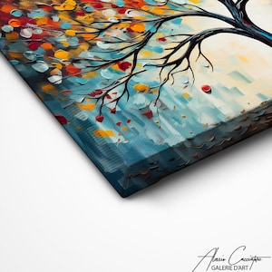May include: A close-up of a canvas art print featuring a tree with black branches and colorful leaves in shades of red, orange, yellow, and blue. The artwork has a textured, impressionistic style. The artist's signature is visible in the bottom right corner.